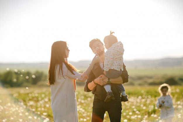 Família jovem feliz, passar o tempo ao ar livre num dia de verão