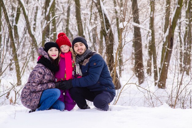 Família jovem feliz posando no parque de neve