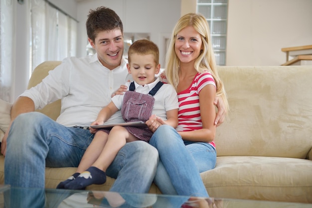 família jovem feliz usando computador tablet em casa moderna para jogar jogos e educação