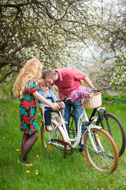 Família jovem, ligado, um, bicycles, em, a, primavera, jardim