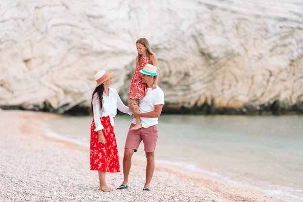 Família jovem na praia branca durante as férias de verão