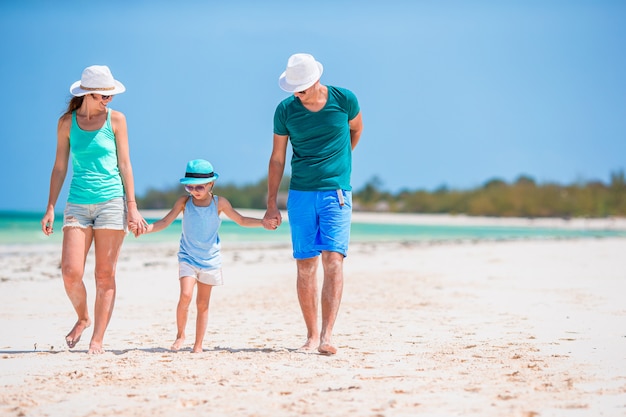 Família jovem na praia branca durante as férias de verão