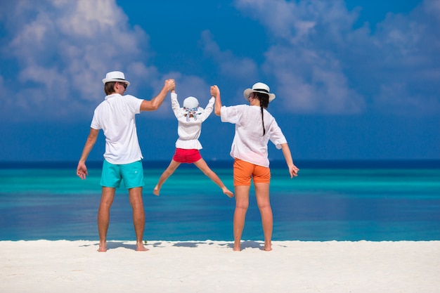 Família jovem na praia branca durante as férias de verão