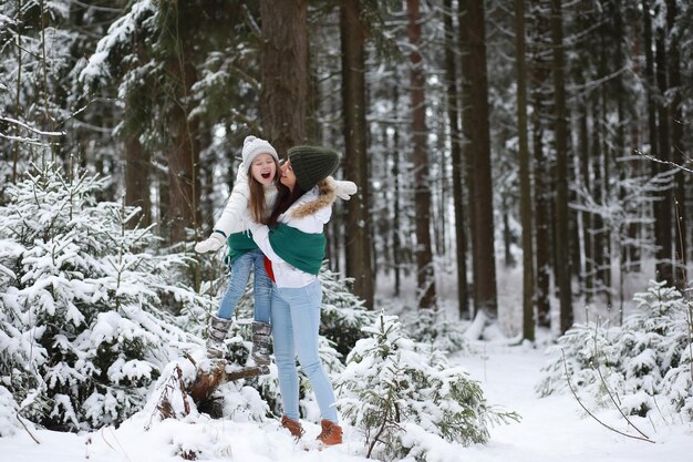 Família jovem para passear Mãe e filha estão andando em um parque de inverno