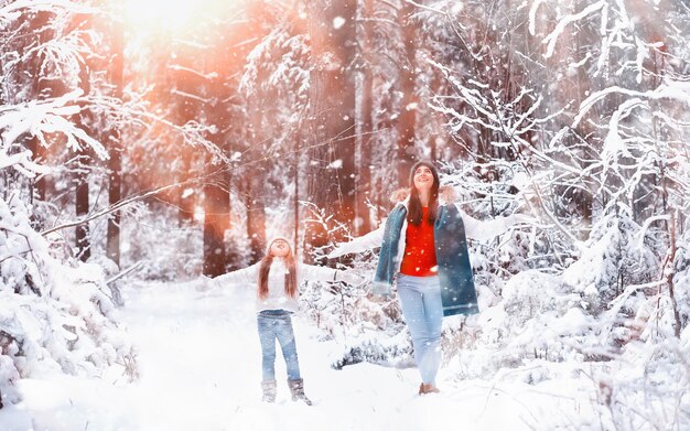 Família jovem para passear. Mãe e filha estão caminhando em um parque de inverno.