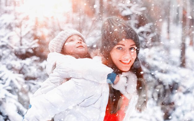 Família jovem para passear. mãe e filha estão caminhando em um parque de inverno.