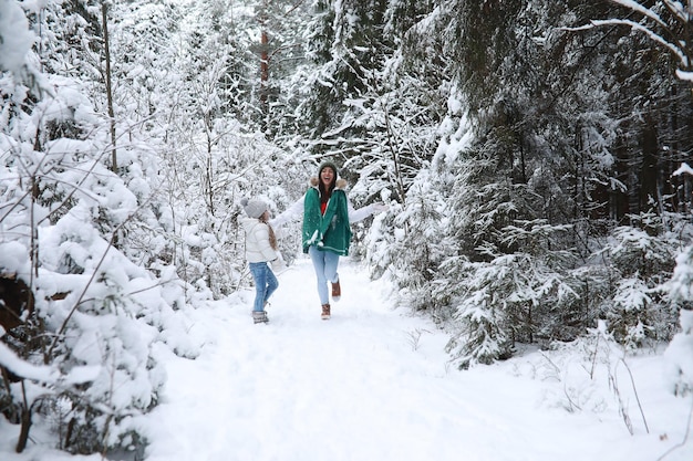 Família jovem para passear. mãe e filha estão caminhando em um parque de inverno.