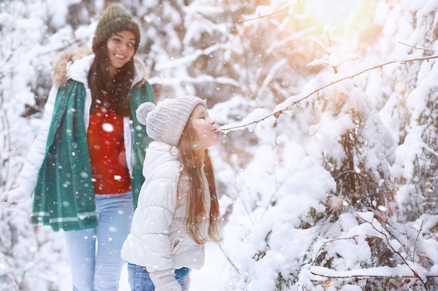 Família jovem para uma caminhada. mãe e filha estão andando em um parque de inverno.