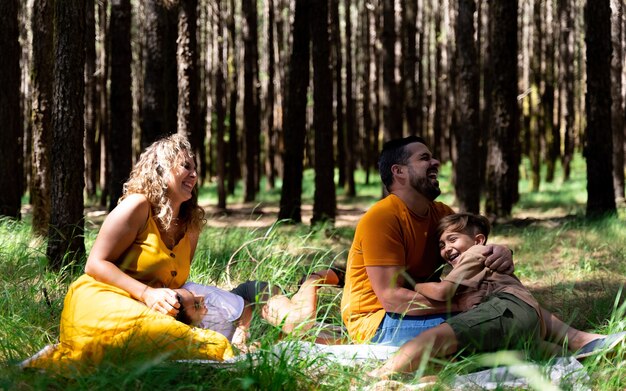 Foto família jovem passando bons momentos juntos na floresta conceito de relações familiares próximas