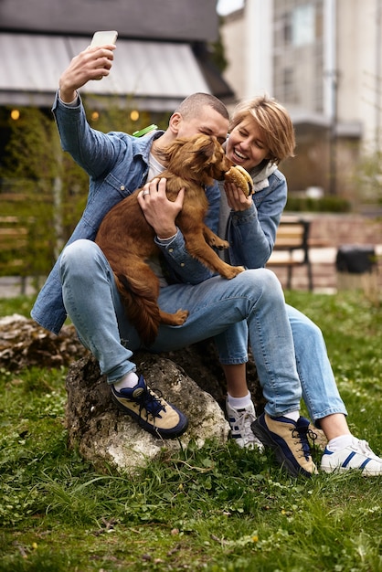 Família jovem passeando com um cachorro pelas ruas da cidade