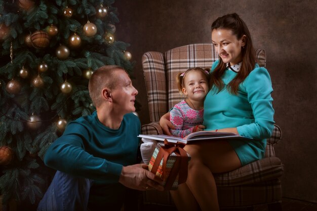 Família jovem perto da árvore de natal