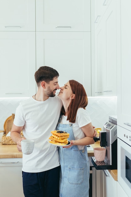 Família jovem preparando o café da manhã juntos, marido e mulher feliz