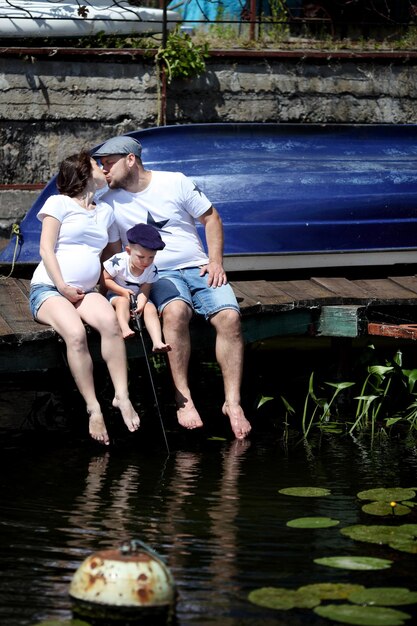 Família jovem sentada à beira do lago