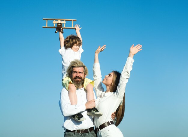 Familia joven al aire libre. Madre, padre e hijo, en la naturaleza en el cielo. Niño chico con avión de juguete.