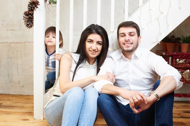 Foto una familia joven en el apartamento decorado para navidad.