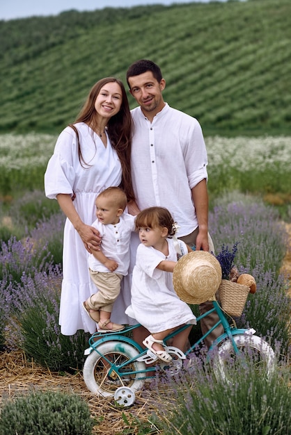 Una familia joven camina con sus hijos en un campo de lavanda.