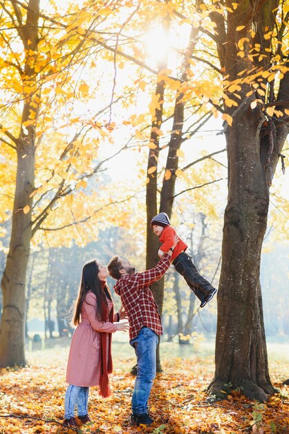 Familia joven caminando en el parque. Otoño.