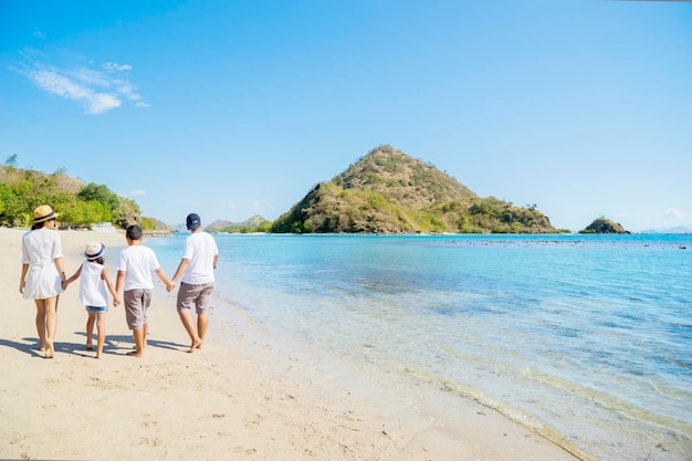 Familia joven caminando por la playa tropical