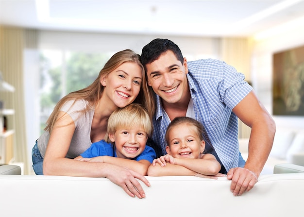 Familia joven en casa sonriendo a la cámara