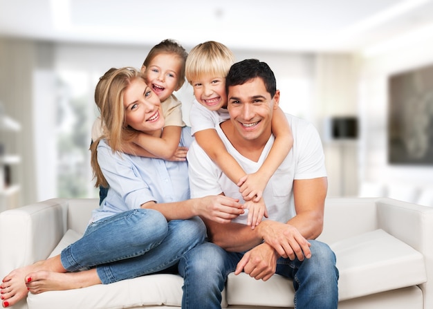 Familia joven en casa sonriendo a la cámara