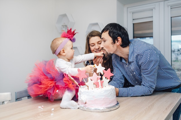 Familia joven celebrando cumpleaños con una torta