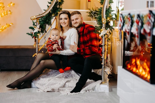 Familia joven celebrando la Navidad en casa. Familia joven feliz disfrutando de sus vacaciones juntos.