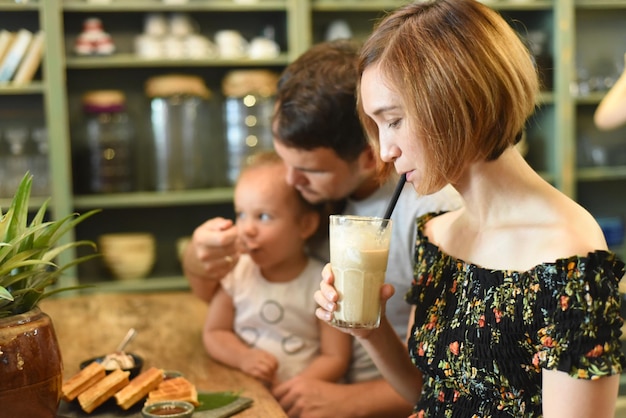 Familia joven comiendo gofres en un café