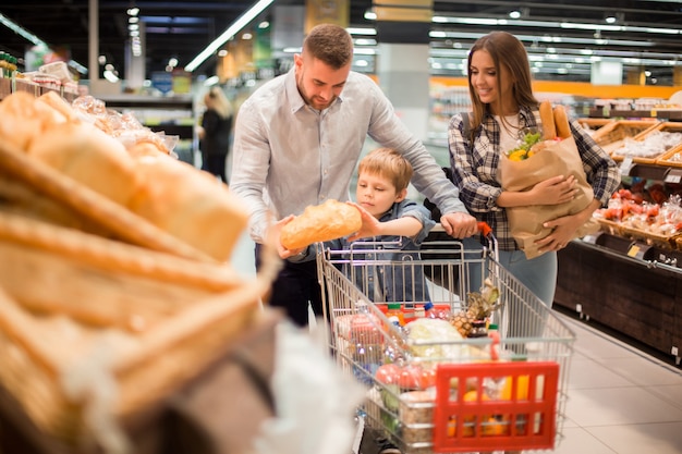 Familia joven comprando pan en supermercado