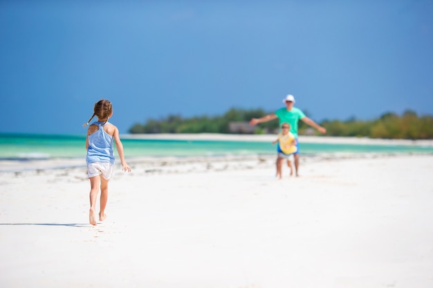 Familia joven disfrutando de vacaciones de verano en la playa. Niños y papá juntos en la playa