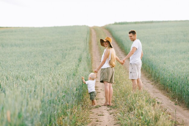 Una familia joven se divierte con su pequeño bebé en el campo