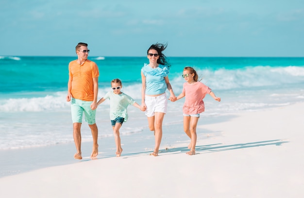 Familia joven con dos hijos en vacaciones en la playa
