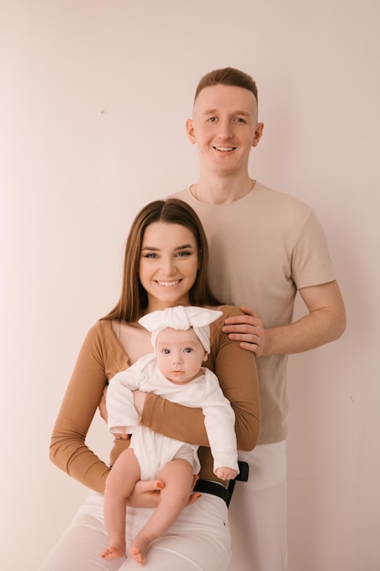 Familia joven con estilo fotografiada con un pequeño y hermoso bebé La familia expresa amor y asombro el uno al otro Concepto de familia y crianza