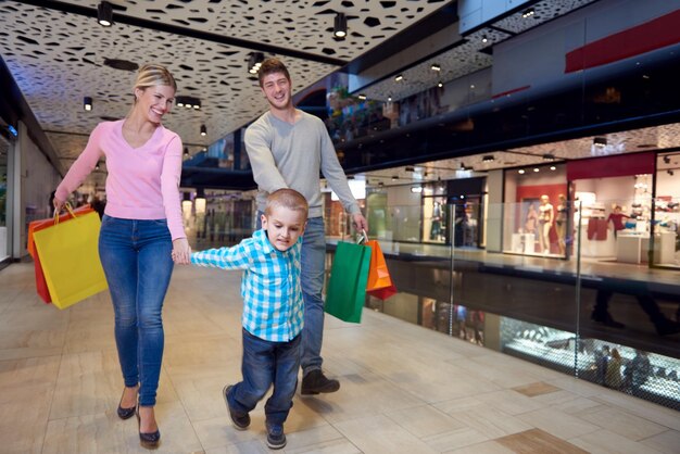 familia joven feliz con bolsas de compras en el centro comercial