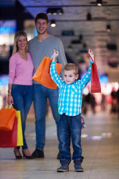 Foto familia joven feliz con bolsas de compras en el centro comercial