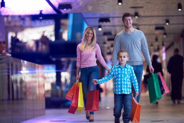 Foto familia joven feliz con bolsas de compras en el centro comercial