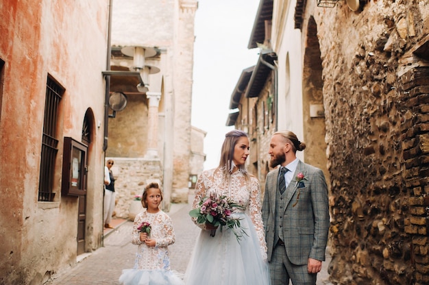 Una familia joven feliz camina por el casco antiguo de Sirmione en Italia