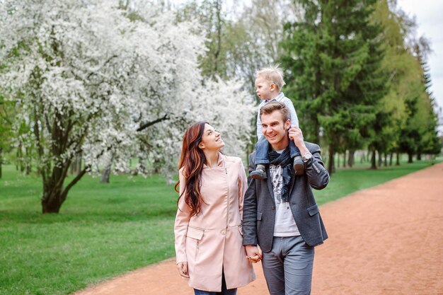 Familia joven feliz caminando en un parque de la ciudad