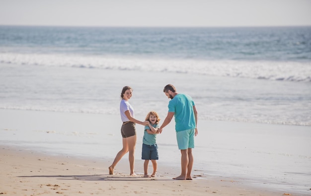 Familia joven feliz corre y salta en la playa de verano niño con padres infancia al aire libre y crianza de los hijos c
