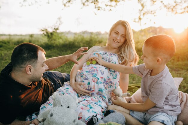 Familia joven feliz descansando en el parque