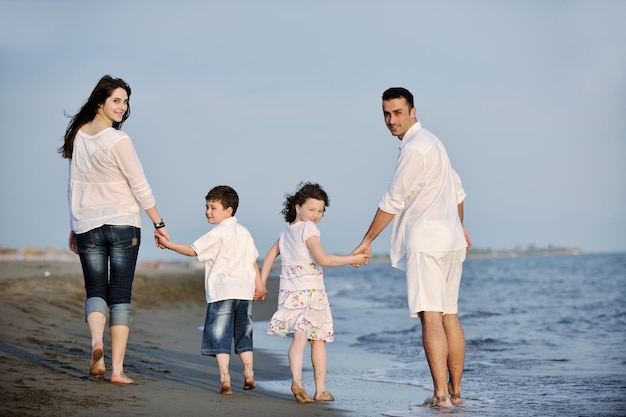 familia joven feliz divertirse y vivir un estilo de vida saludable en la playa