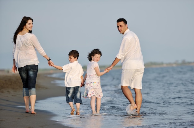 familia joven feliz divertirse y vivir un estilo de vida saludable en la playa