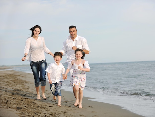 familia joven feliz divertirse y vivir un estilo de vida saludable en la playa