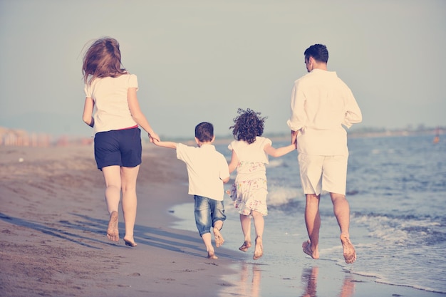 familia joven feliz divertirse y vivir un estilo de vida saludable en la playa