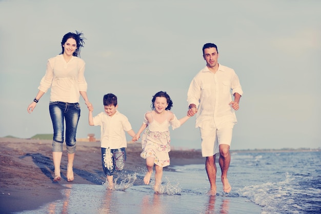 familia joven feliz divertirse y vivir un estilo de vida saludable en la playa