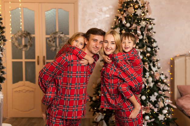 Familia joven feliz con dos niños sonriendo