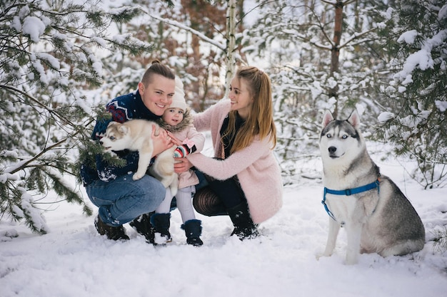 familia joven feliz jugando con perros en el parque de invierno