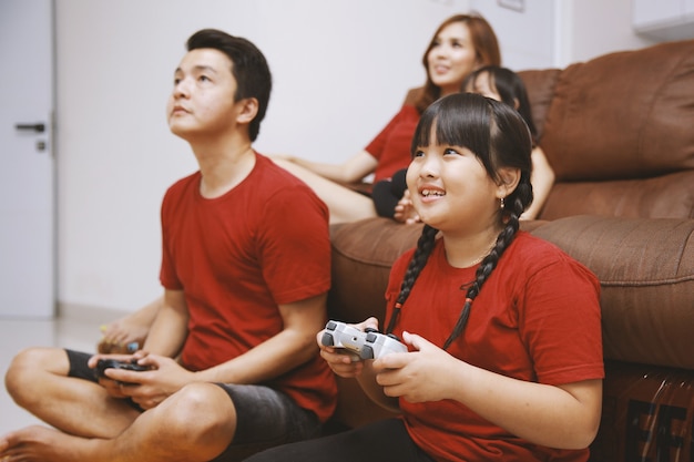 Familia joven feliz jugando videojuegos en casa