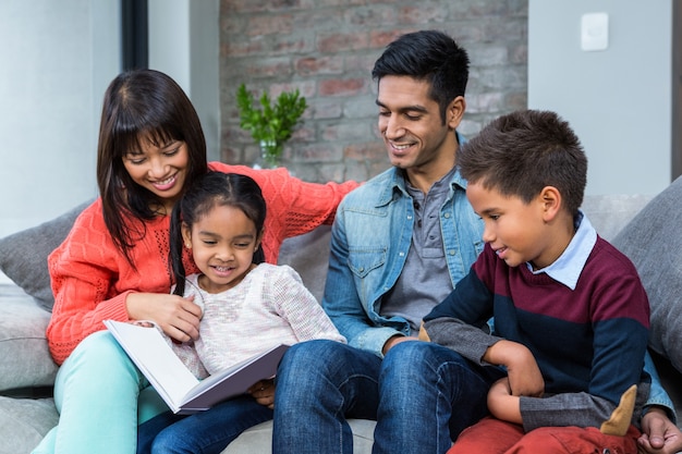 Familia joven feliz leyendo un libro juntos