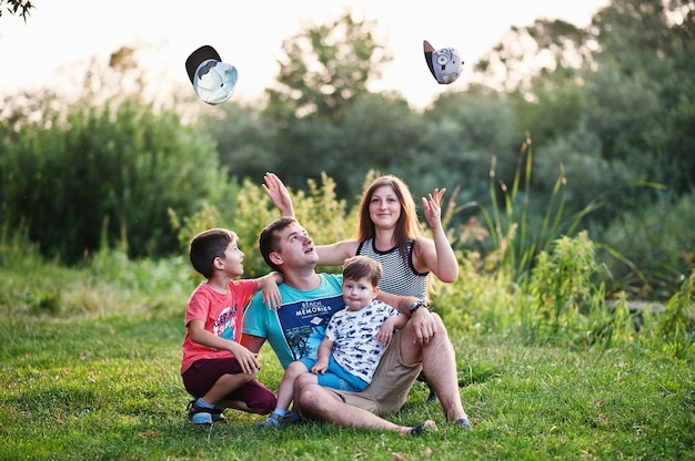 Familia joven feliz: madre, padre, hijo de dos hijos en la naturaleza divirtiéndose.