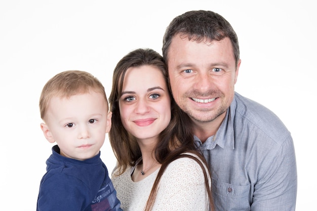 Familia joven feliz con niño bonito posando sobre fondo blanco